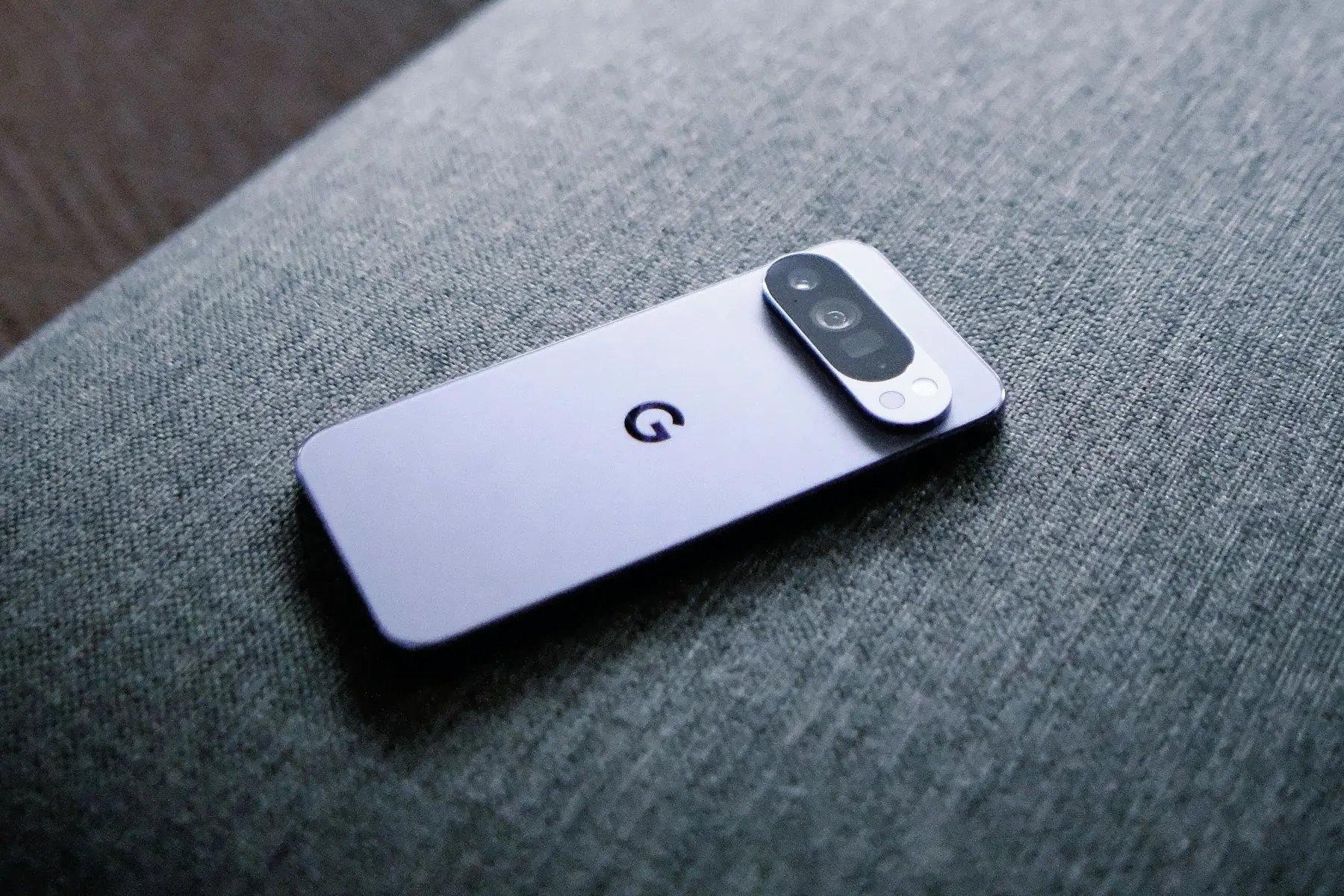 Smartphone Google Pixel posé sur un canapé gris.
